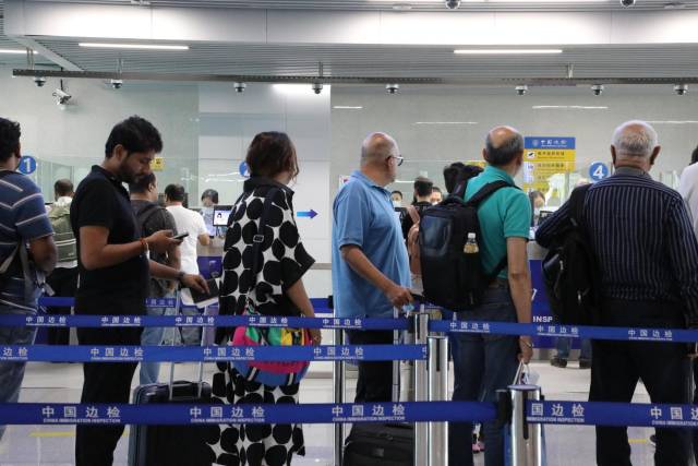 广交会客商正在琶洲港澳客运口岸排队等候入境边防检查。李艳 摄