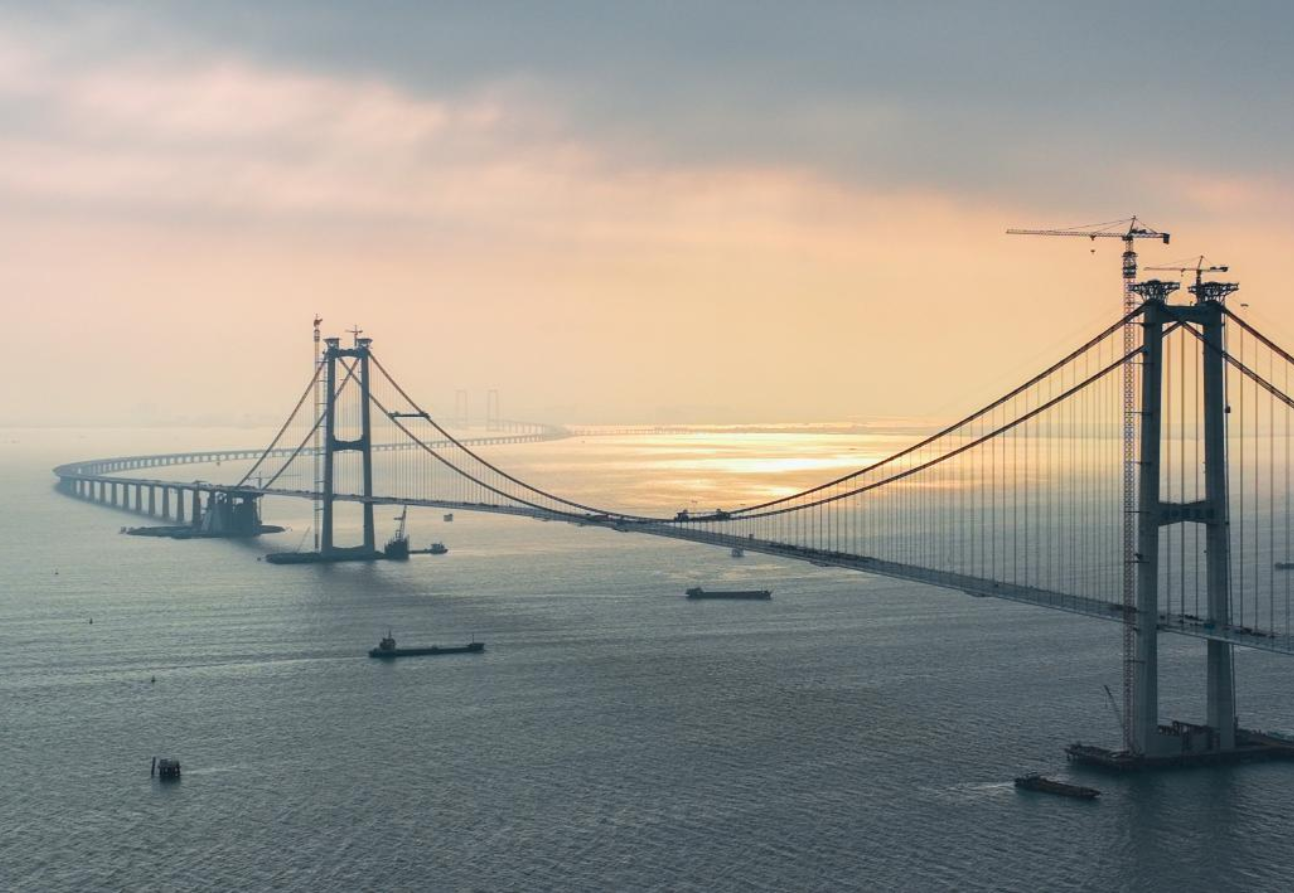 2023年4月28日，深中大桥合龙，标志着深中通道项目桥梁工程实现全线合龙。深中大桥是深中通道又一关键控制性工程，今年6月8日，由“伶仃洋大桥”更名为“深中大桥”，其桥面高91米、主跨1666米，建设过程中创下了世界最大跨径全离岸海中钢箱梁悬索桥、最高通航净空、最大海中锚碇等多项世界之最。图为夕阳下的深中大桥。