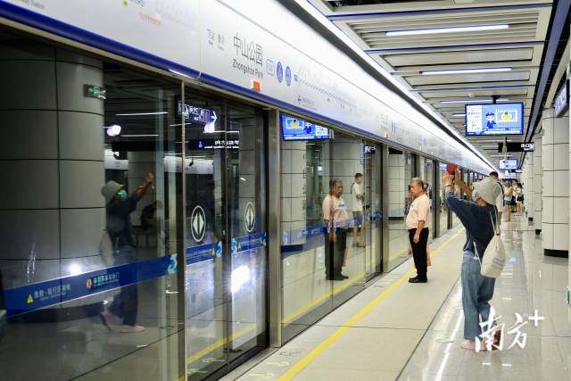 市民在中山公园站拍照留念、排队候车。刘佳伦 摄