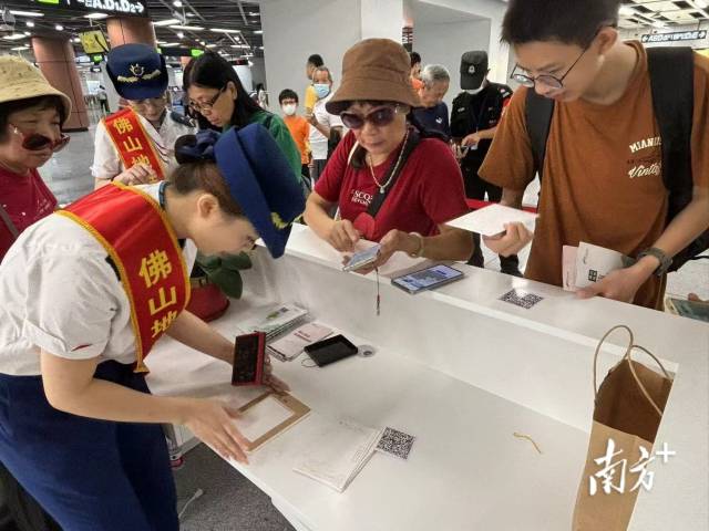 市民在桂城站便民服务台用明信片盖章打卡。龙西男 摄