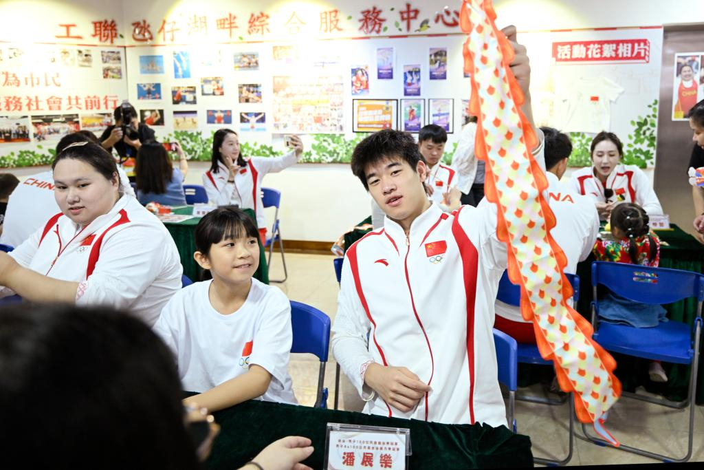 9月2日，在澳门工联氹仔湖畔综合服务中心，游泳运动员潘展乐（右）展示与小朋友一起制作的灯笼。当日，内地奥运健儿代表团走进澳门社区，分别到妇联乐满家庭服务中心、街总石排湾家庭及社区综合服务中心和工联氹仔湖畔综合服务中心与市民互动。新华社发