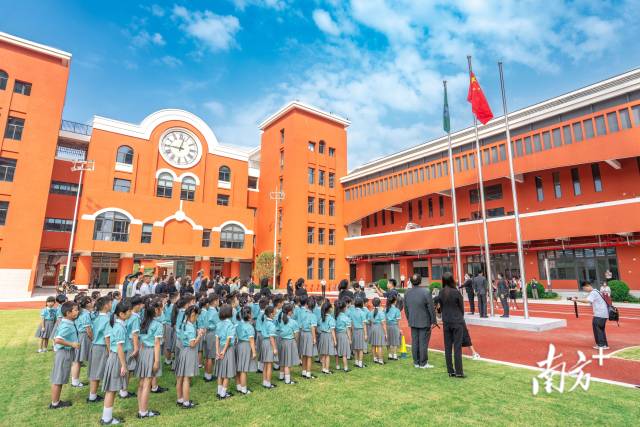 澳门新生身穿校服，背着书包来到濠江中学附属横琴学校报到。