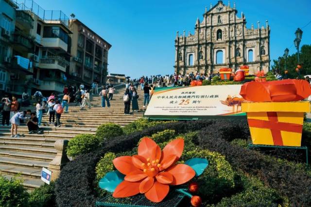 12月5日，澳门大三巴牌坊，“热烈庆祝中华人民共和国澳门特别行政区成立25周年”的标志吸引游客留影。图/视觉中国