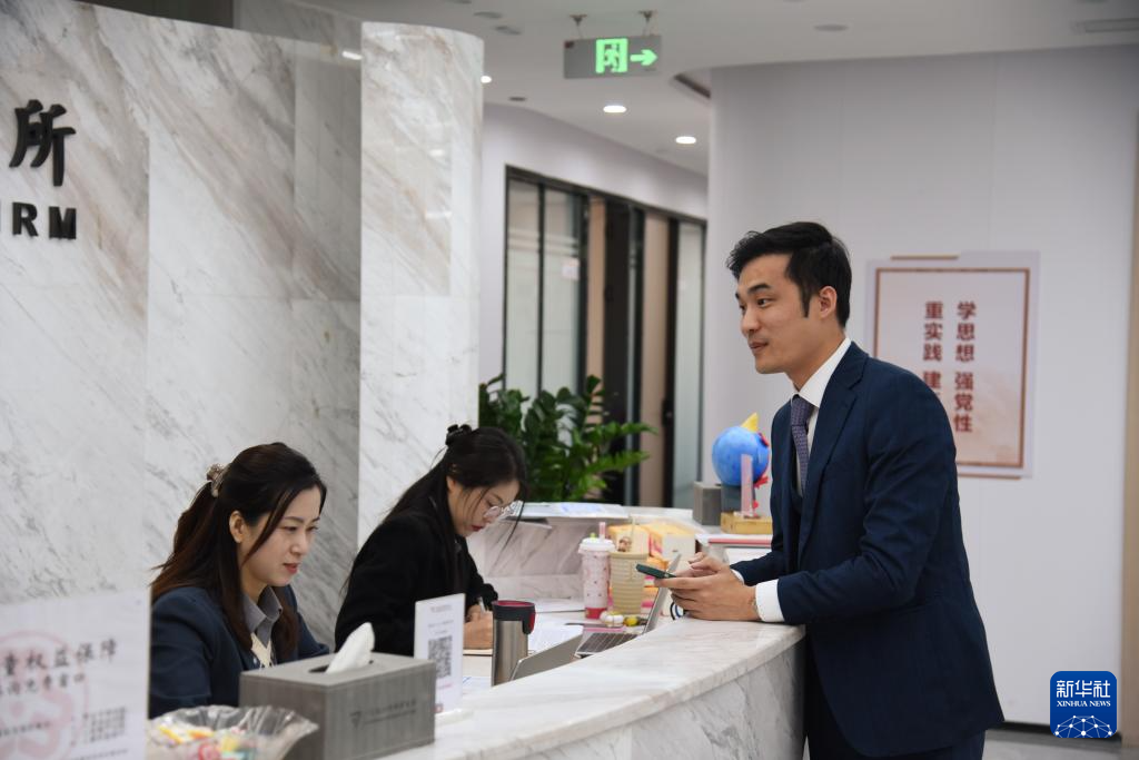 澳门律师阮嘉锐（右）在和同事交谈（12月19日摄）。新华社记者 洪泽华 摄