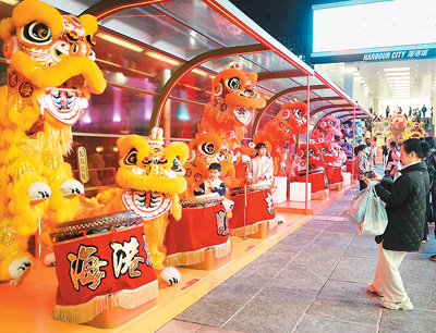 近日在香港维多利亚港畔，游客和醒狮合影。新华社记者 褚萌萌摄