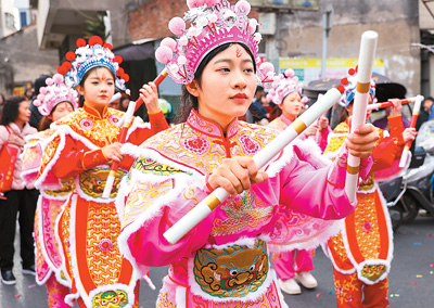  春节期间，英歌舞队员在广东省汕头市潮阳区海门镇街头巡游表演。王文摄（人民视觉）