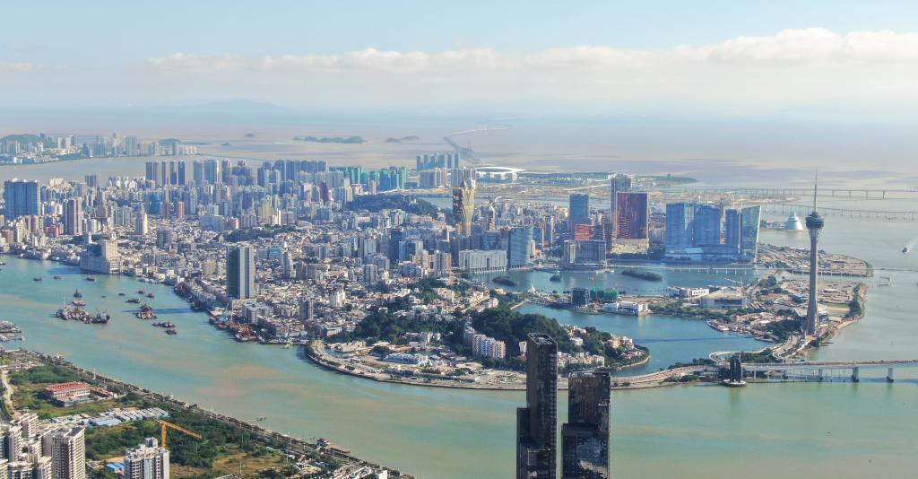 从珠海市区拍摄的澳门及远处的港珠澳大桥（2024年11月26日摄，无人机照片）。新华社记者 邓华 摄