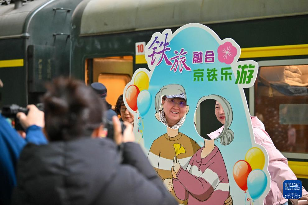 3月15日，在天津站站台，银发族游客在“京铁乐游”号银发旅游列车发车前拍照留念。新华社记者 孙凡越 摄