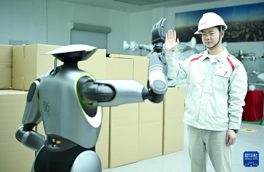 在位于广州的广汽研究院，技术人员演示人形机器人GoMate互动功能（3月18日摄）。