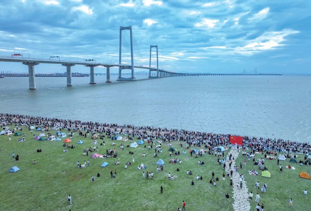 2024年10月，广东中山，市民在深中通道起步点大草坪等待日出
