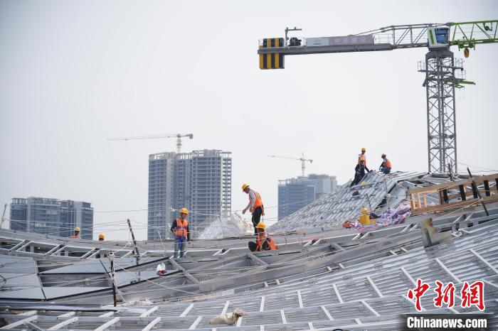 建设者们忙于幕墙工程、金属屋面、机电安装、精装修施工。记者 韦杰夫 摄