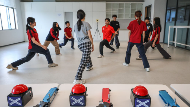 图为广东现代五项运动协会教练员滕泽华（中）带领广州市中黄港澳子弟学校学生进行拉伸训练
